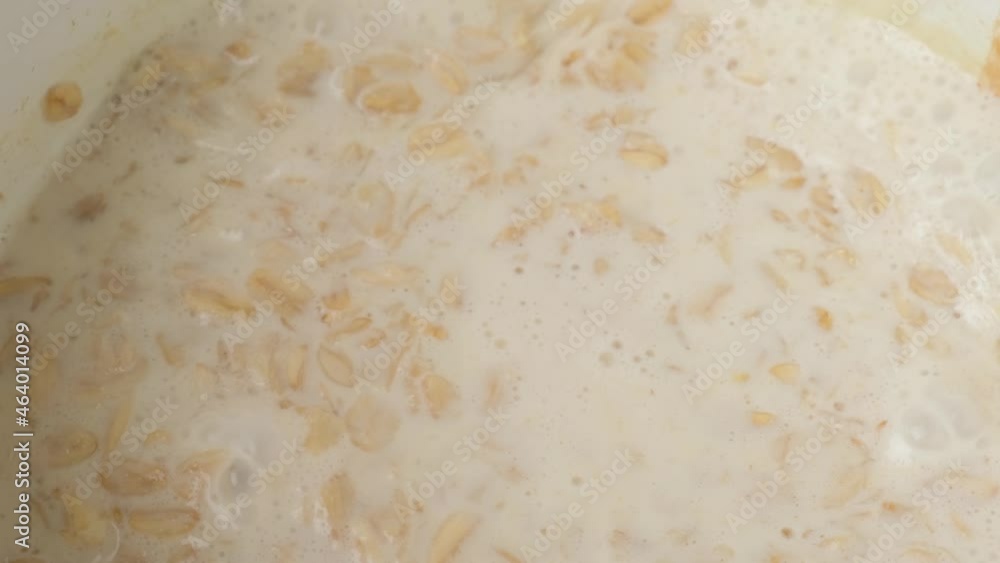 Cooking oatmeal porridge in saucepan and stir with wooden spoon. Close up. 4k video. Healthy breakfast Cooking oatmeal porridge in saucepan and stir with wooden spoon. Close up. 4k video. Healthy breakfast