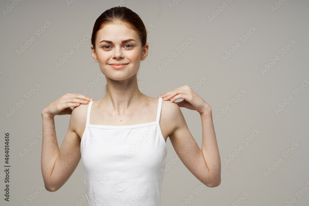 Obraz premium woman doing shoulder exercises health gray background