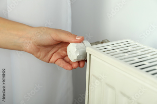 Concept of heating season with hand adjusts the radiator