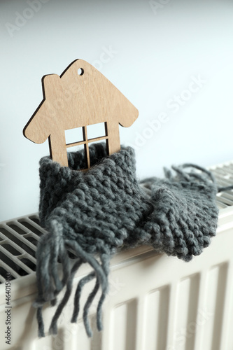 Concept of heating season with wooden house on heating radiator