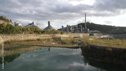 Abandoned Dutch Cement industry factory at chalk and limestone quarry in Limburg, the Netherlands with beautiful colored lake photo