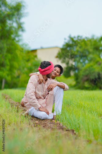 Indian farmer with his son at agriculture field.