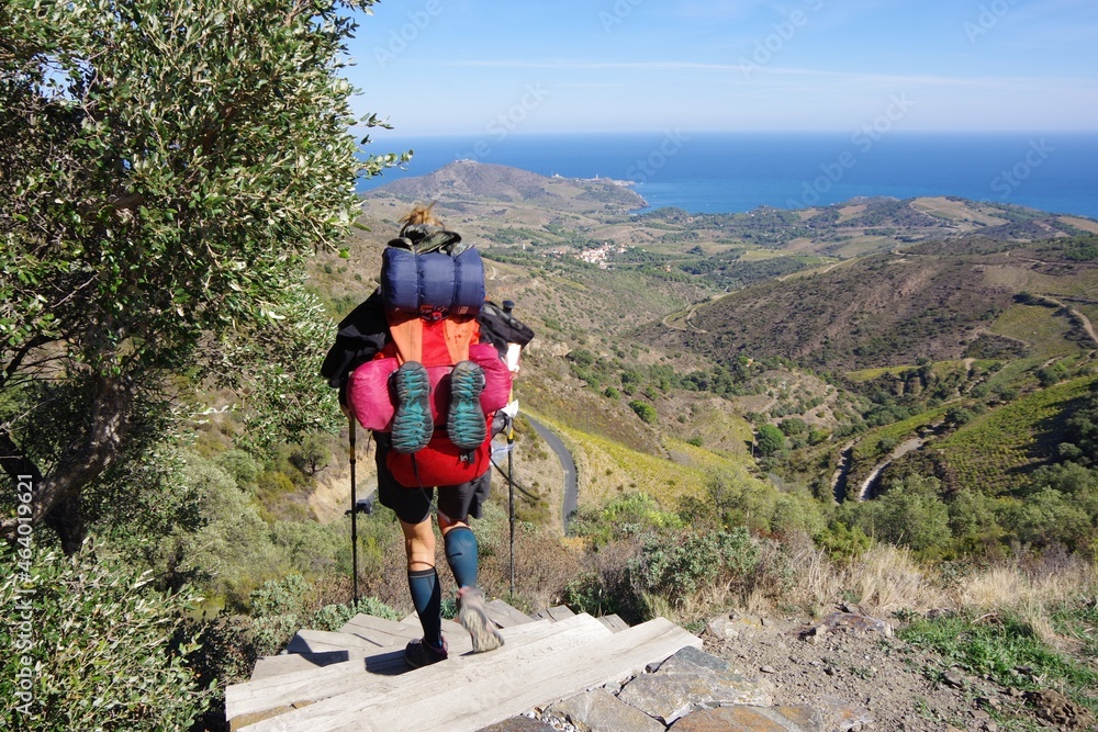 randonneuse avec gros sac à dos sur le sentier GR1 0 qui arrive à la mer vers Banyuls dans les pyrénées randonneuse avec gros sac à dos sur le sentier GR1 0 qui arrive à la mer vers Banyuls dans les pyrénées
