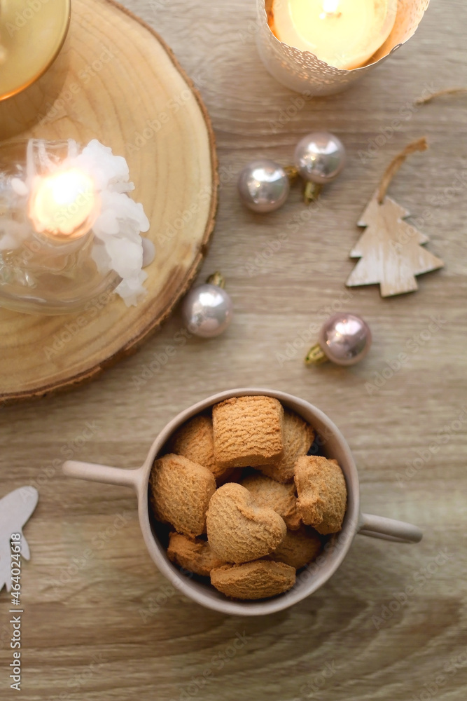 Bowl of cinnamon cookies, lit candles and various Christmas decorations on the table. Flat lay. Bowl of cinnamon cookies, lit candles and various Christmas decorations on the table. Flat lay.