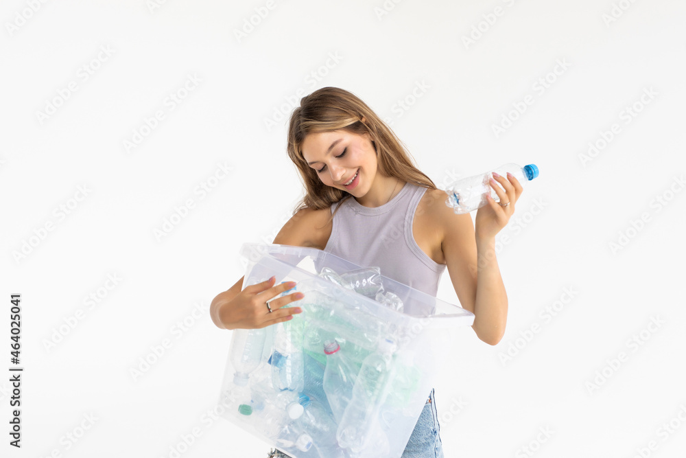 Young woman recycling plastic bottles in a bin isolated over white background Young woman recycling plastic bottles in a bin isolated over white background