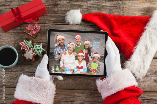 Santa claus holding tablet, making christmas video call with caucasian multi generation family
