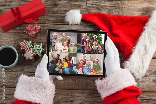 Santa claus making tablet christmas video call with smiling diverse families
