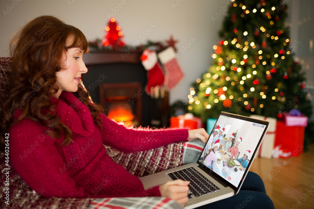 Smiling caucasian woman making laptop christmas video call with smiling multi generation family Smiling caucasian woman making laptop christmas video call with smiling multi generation family