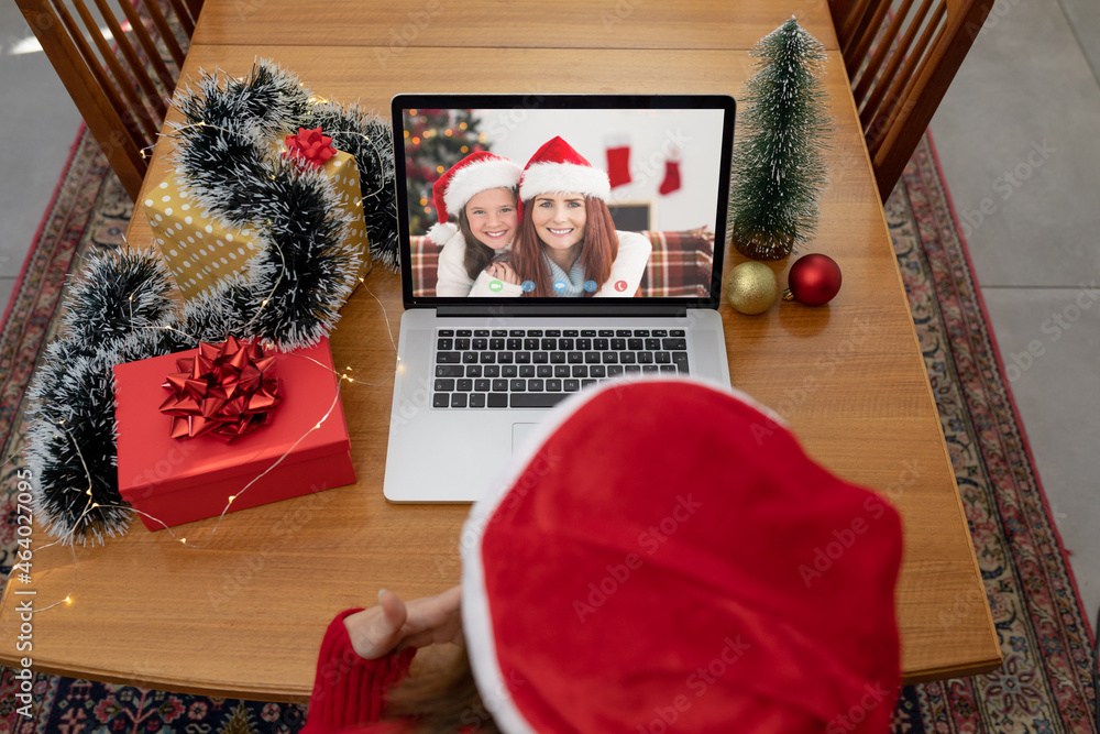Obraz premium Caucasian woman on christmas laptop video call with caucasian mother and daughter