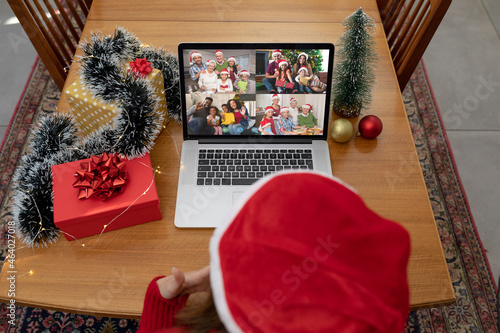 Caucasian woman on christmas laptop video call with diverse group of friends photo