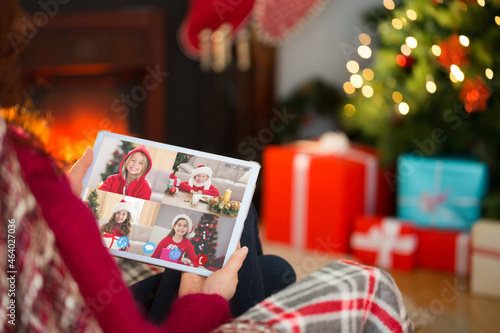 Caucasian woman on christmas tablet video call with caucasian group of children