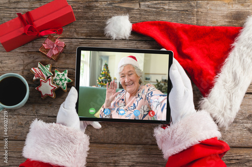 Caucasian santa claus on christmas laptop video call with caucasian senior woman