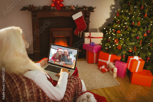 Caucasian santa claus on christmas laptop video call with caucasian couple