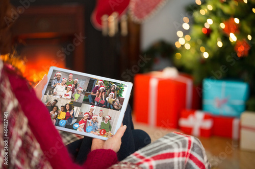 Caucasian woman on christmas laptop video call with diverse group of friends photo