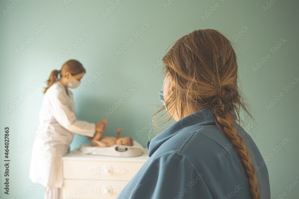 Obraz premium Baby on weight scale at the doctor