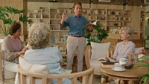 Senior adult discussing a book in book club,4K