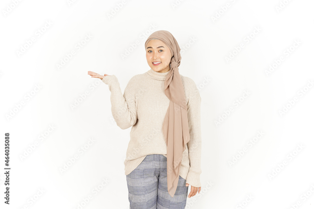 Presenting product on open palm of Beautiful Asian Woman Wearing Hijab Isolated On White Background Presenting product on open palm of Beautiful Asian Woman Wearing Hijab Isolated On White Background