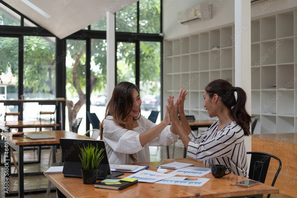 Two happy friendly business people giving high five in office celebrating success, good cooperation result, partnership teamwork and team motivation in office work