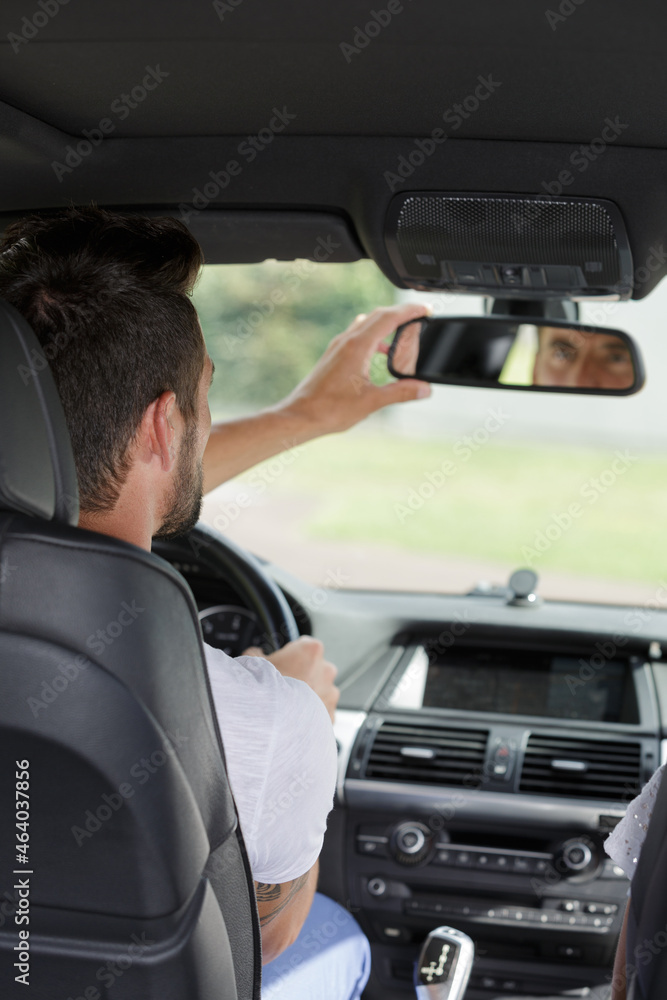 man in car looking at mirror inside man in car looking at mirror inside