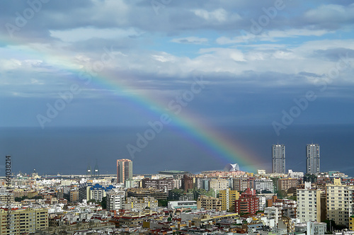 Rainbow in the city at sunset with sun. Tenerife. Canary Islands.