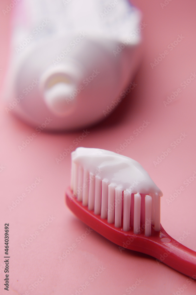 tooth brush and paste on pink 