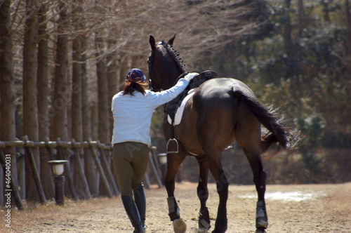 飛越競技を終えてきゅう舎へ帰る競走馬と女性厩務員 © rivermountain