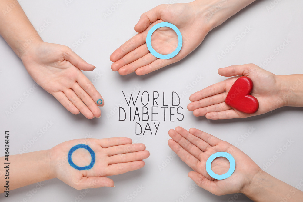 People showing blue circles and red heart near text World Diabetes Day on light background, top view People showing blue circles and red heart near text World Diabetes Day on light background, top view