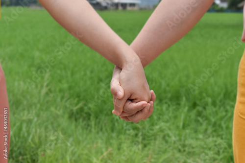 Two female holding hands in nature outdoor. Selective focus