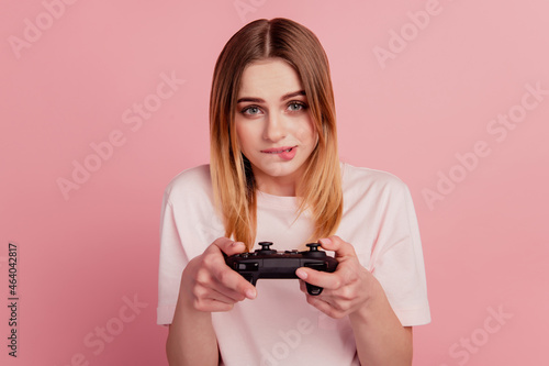 Photo of young woman bite lips addicted play video game loser joystick isolated on pink color background