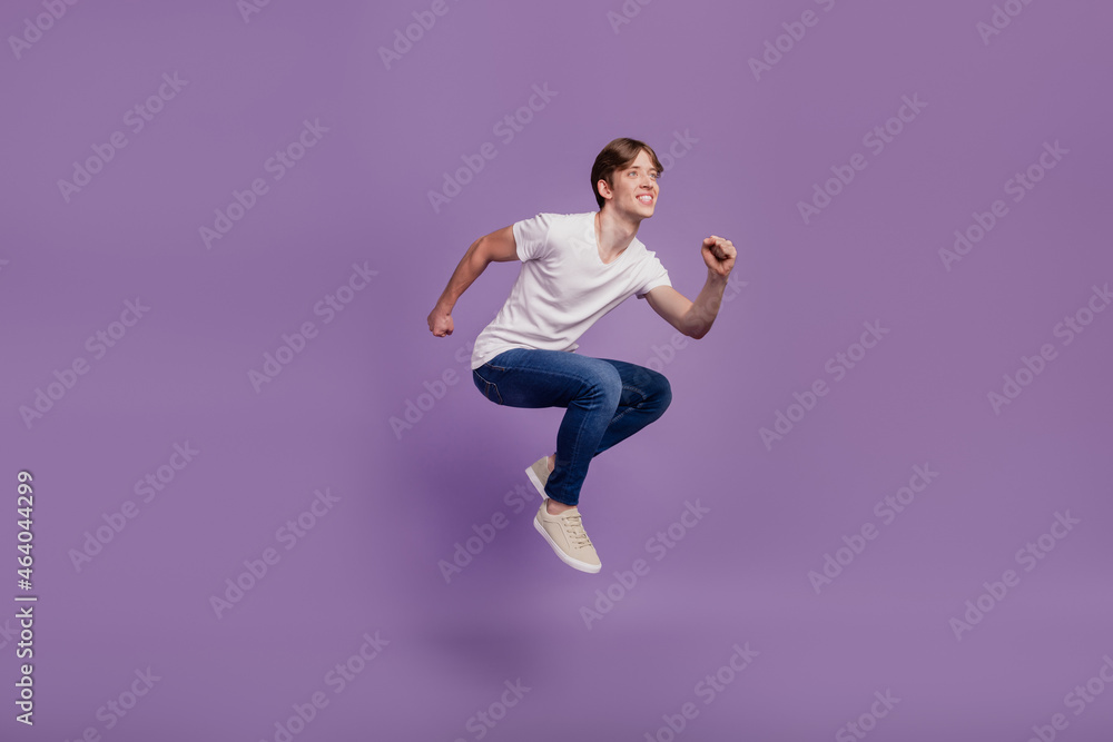 Full size profile side photo of young man have fun jump go run look empty space fast isolated on violet color background