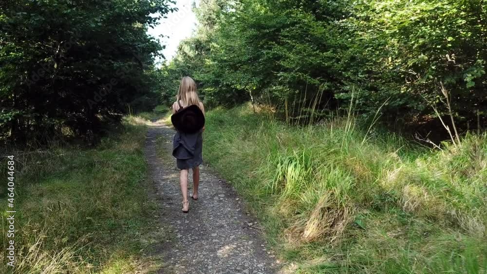 Young girl walking barefoot alone on a forest path Young girl walking barefoot alone on a forest path