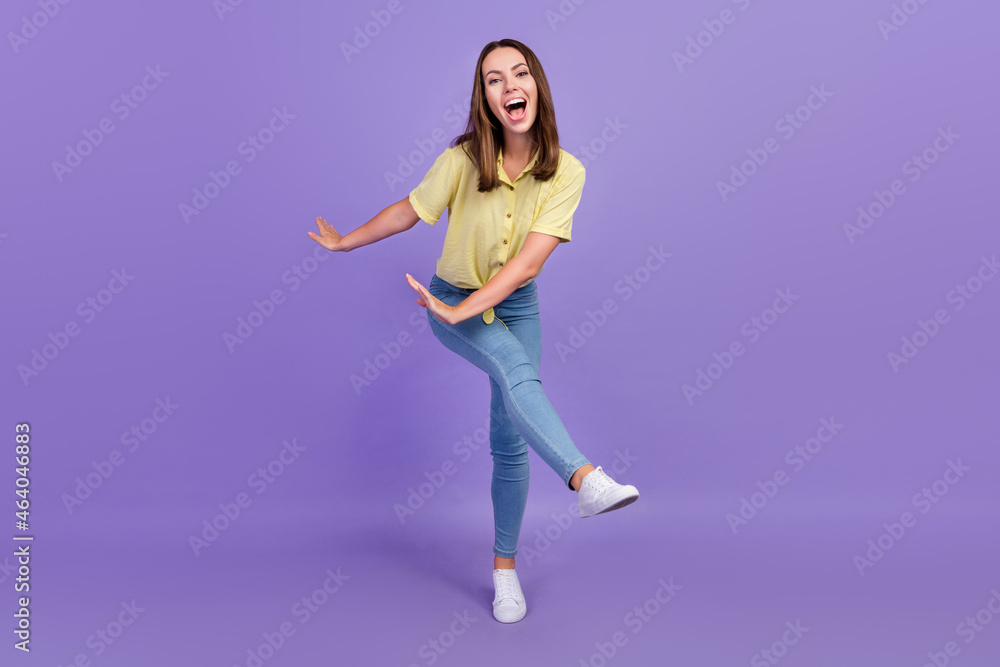 Full length photo of funky young brunette lady dance wear yellow top jeans shoes isolated on purple color background