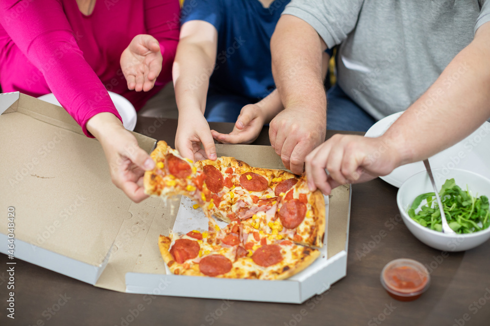 The family divides the pizza slices among themselves.