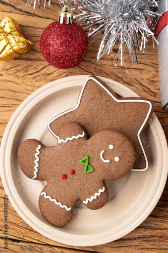 Traditional christmas gingerbread cookies over a wooden table with gift box christmas decoration