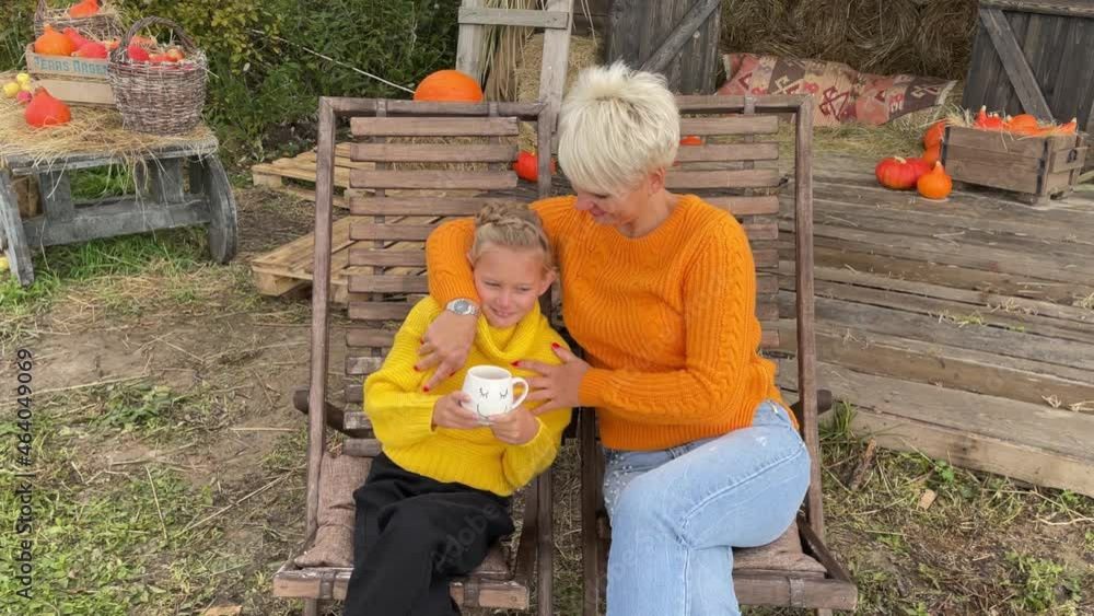 mom and daughter are resting and enjoying an autumn day outdoors in sun loungers, picnic in nature in autumn, mom and daughter are drinking hot tea sitting in a sun lounger. High quality 4k video mom and daughter are resting and enjoying an autumn day outdoors in sun loungers, picnic in nature in autumn, mom and daughter are drinking hot tea sitting in a sun lounger. High quality 4k video