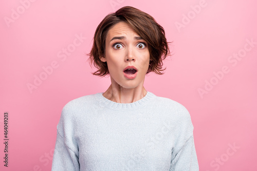 Photo of amazed shocked young woman afraid scared problem bad mood astonished isolated on pink color background photo