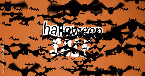 Animation of halloween writing and bats floating on orange background