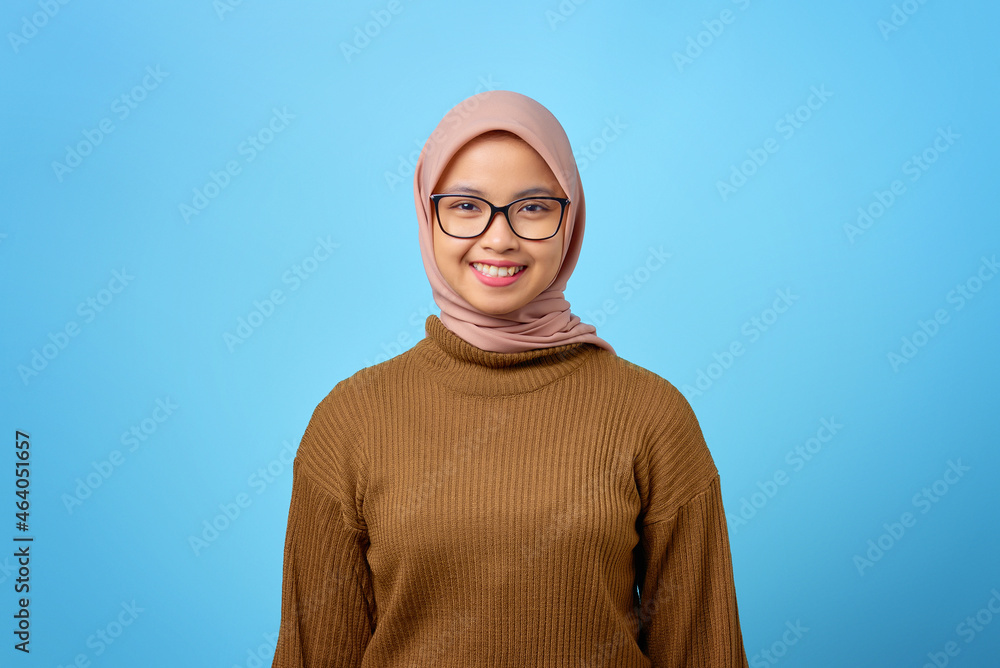 Portrait of happy young Asian woman with smiling face on blue background Portrait of happy young Asian woman with smiling face on blue background