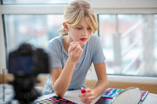 A pretty young girl making online tutorial about make up photo