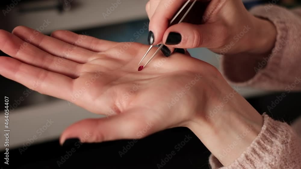 Woman Jeweler Examines Ruby Gemstone Using Tweezers Woman Jeweler Examines Ruby Gemstone Using Tweezers