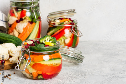 Fermented vegetables in glass jars. Fermented preserved vegetarian food. Homemade canned food concept. Various pickled vegetables.