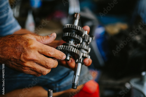 Maintenance and repair of the motorcycle engine transmission system by a mechanic.  © กอล์ฟ สแตนดาร์ด