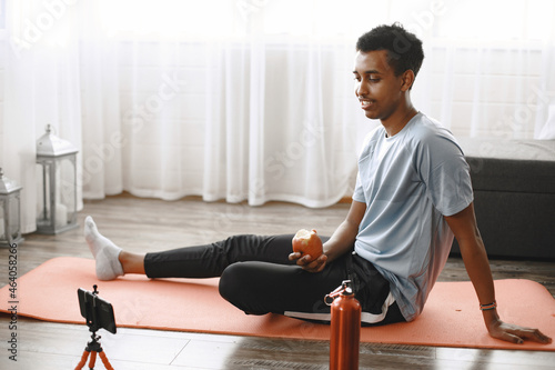 Young sporty man filming morning exercise on camera