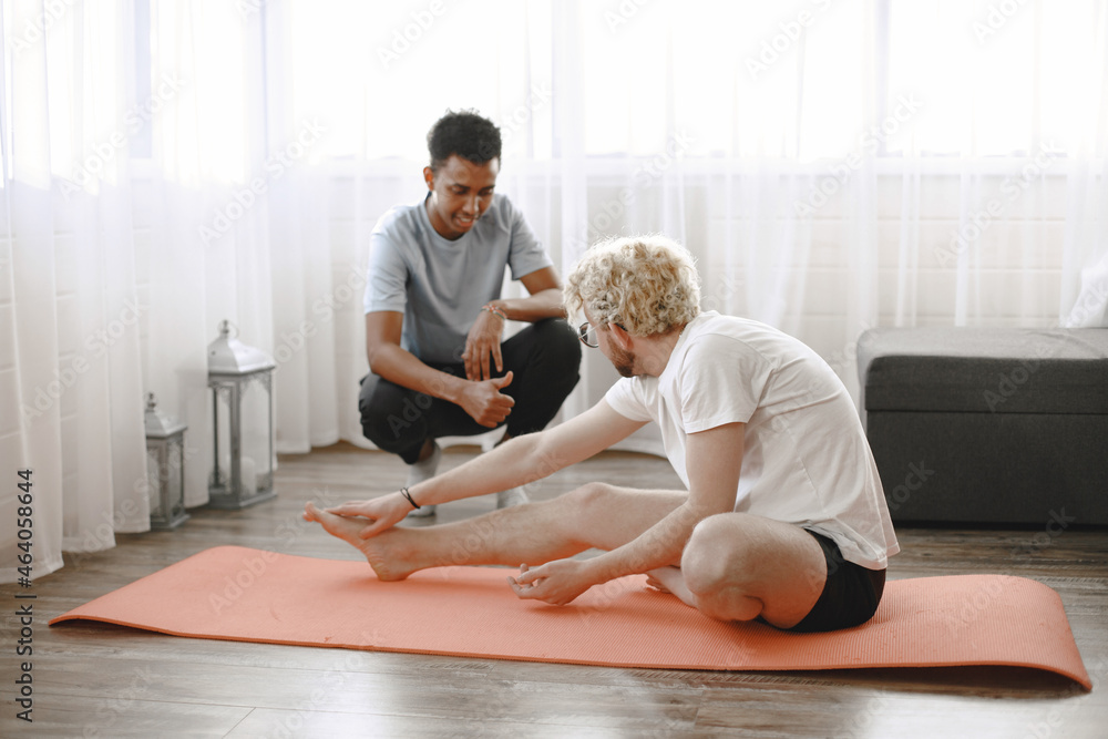 Coach doing exercises with man at home