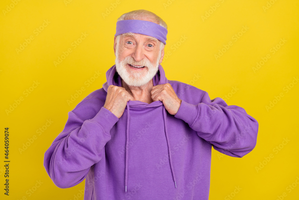 Photo of mature man good mood cool hands touch collar sporty outfit isolated over yellow color background