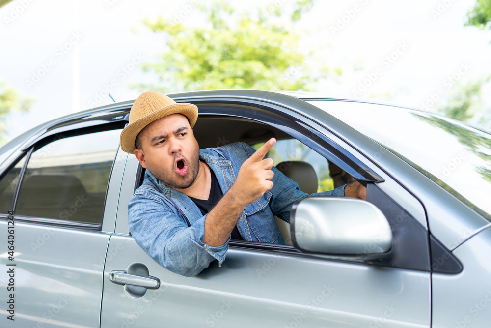 Happy male driver smiling while sitting in a car with open front window. Young asian man smile and looking through window enjoying trip. Man driving his car to travel on his holiday vacation time. Happy male driver smiling while sitting in a car with open front window. Young asian man smile and looking through window enjoying trip. Man driving his car to travel on his holiday vacation time.