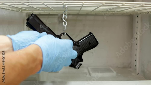 csi police, revealing fingerprints on a gun in a Cyanoacrylate fuming chamber photo