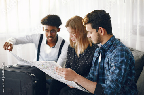 Group of diverse friends looking at map in the bright room