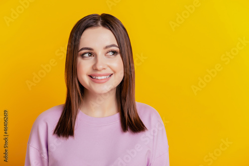Photo of young lovely lady curious dream wonderred look empty space isolated over yellow color background