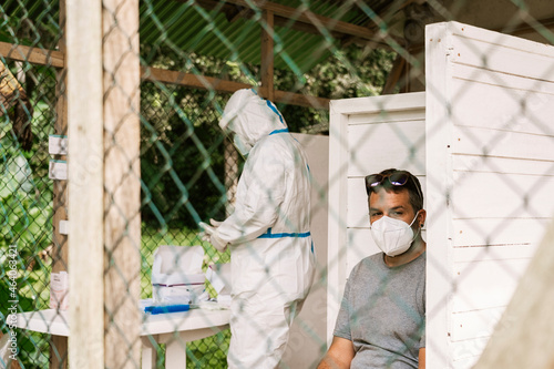 Ethnic man in mask waiting vaccination during coronavirus pandemic photo